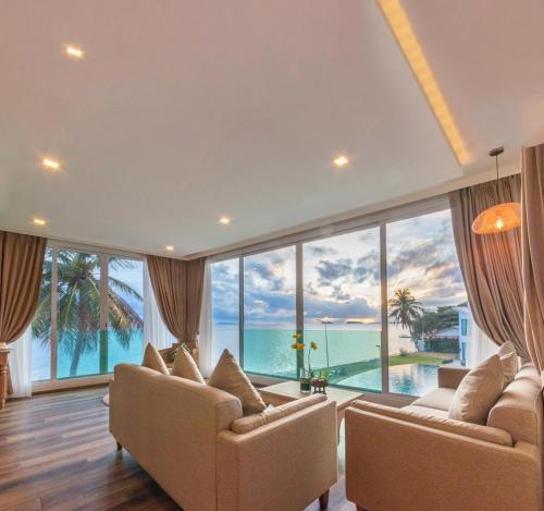 a living room with a view of the ocean at Vannee Golden Sands Beachfront Resort in Haad Rin