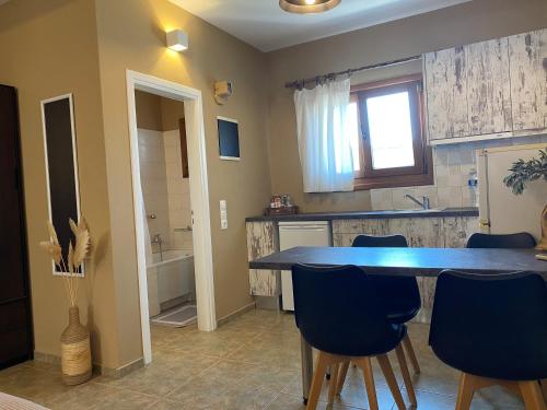 a kitchen with a blue table and blue chairs at Kea Petra Studios in Korissia