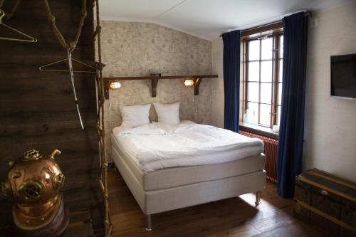 a bedroom with a white bed and a window at Hotell Vaxblekaregården in Eksjö