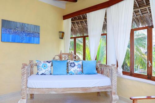 a room with a bench in front of a window at Baharini Beachfront Cottage in Malindi