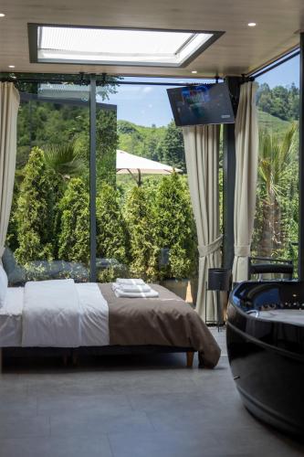 1 dormitorio con cama y ventana grande en Mirror Land Bungalov, en Rize