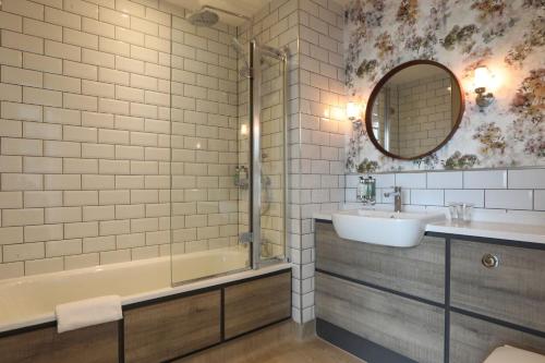 a bathroom with a sink and a tub and a mirror at The Harrogate Inn - The Inn Collection Group in Harrogate