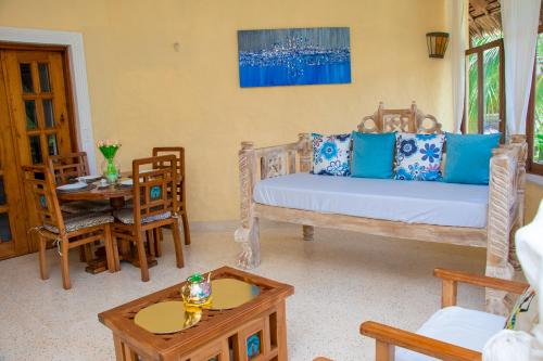 a living room with a bed and a table at Baharini Beachfront Cottage in Malindi