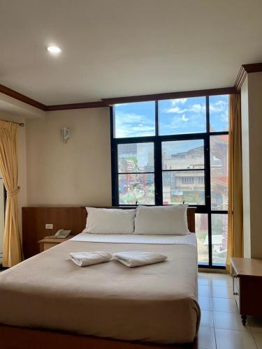a bedroom with a large bed with a large window at Wantana Mansion Check in before 8 pm in Hat Yai