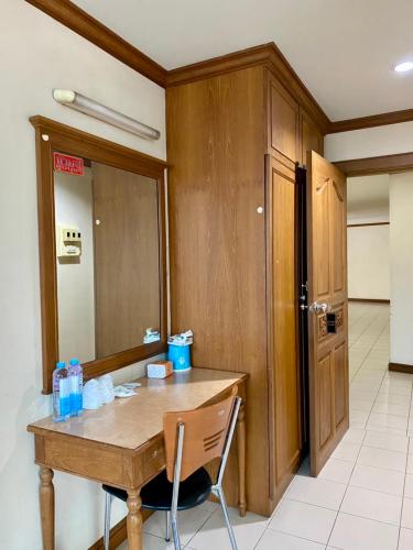 a wooden table with a chair in a room at Wantana Mansion Check in before 8 pm in Hat Yai