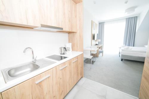 a kitchen with a sink and a bathroom with a bed at VacationClub - Aparthotel Czarna Góra 319 in Sienna
