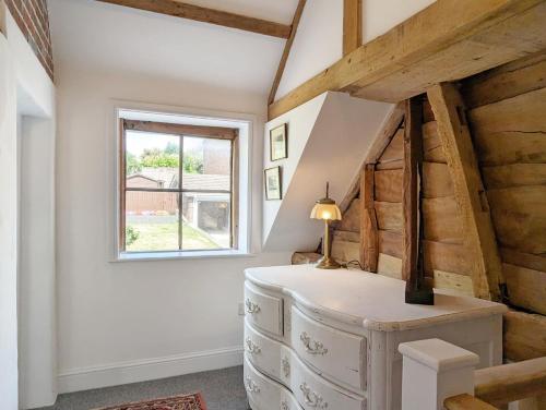 Zimmer im Dachgeschoss mit einer Treppe und einem Fenster in der Unterkunft Mabel Cottage, Wickham in Wickham