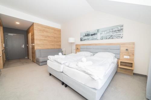 um quarto com uma cama grande e lençóis brancos em VacationClub - Aparthotel Czarna Góra 309 em Sienna