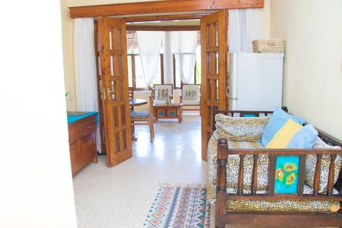 a living room with a couch and a refrigerator at Tembo Baharini Beach Cottage in Malindi