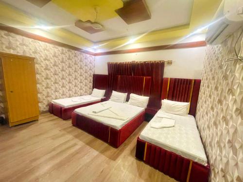 Habitación con 2 camas en una habitación en Rehaish Inn Model Colony en Karachi