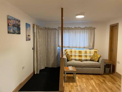- un salon avec un canapé et une fenêtre dans l'établissement Poshington willows accessibility friendly, à Weymouth
