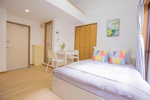 a bedroom with a large bed and a table at 閑静な住宅街_暖かく居心地の良いデザイン YoY-6 in Tokyo
