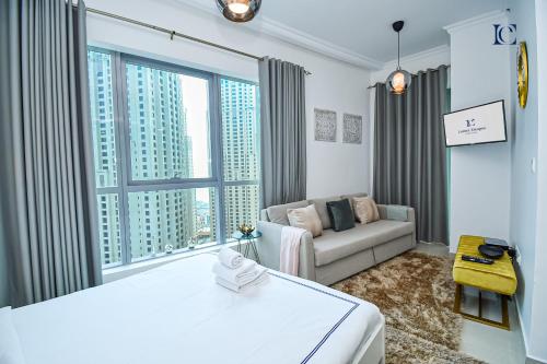 um quarto com duas camas e um sofá e uma janela em Newly Furnished Studio with Marina View - PAU em Dubai