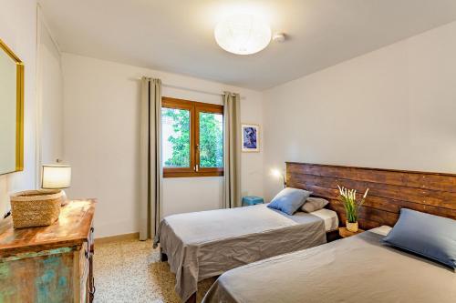 a bedroom with two beds and a window at Can Picarola in Santanyi