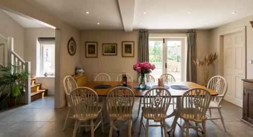 a dining room with a table and chairs at Warren House and Spa boutique Cotswold stay in Cirencester