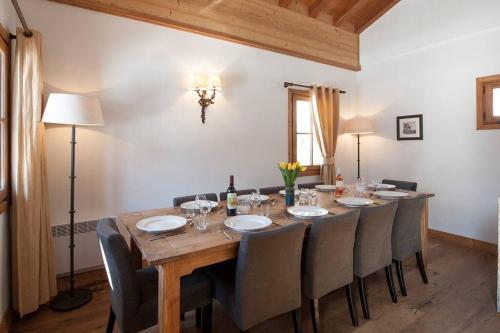 - une table à manger avec des chaises et une bouteille de vin dans l'établissement Powder Ridge - 6 bedroom chalet with hot tub, à Tignes