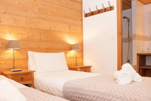 two beds in a hotel room with two white towels at Powder Ridge - 6 bedroom chalet with hot tub in Tignes