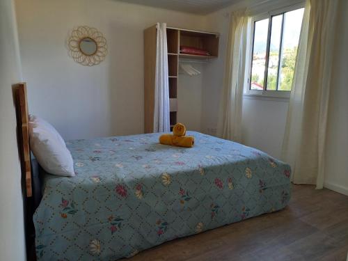 Un osito de peluche sentado en una cama en un dormitorio. en L'Etreinte des Cimes, en Cilaos