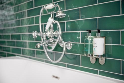 a shower in a green tiled bathroom with a sink at The Royal Inn by Chef & Brewer Collection in Bristol