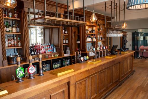 a bar with a wooden counter with alcohol bottles at The Royal Inn by Chef & Brewer Collection in Bristol