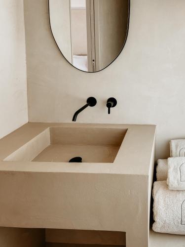 a bathroom with a sink and a mirror at Casa dos Mercados in Olhão