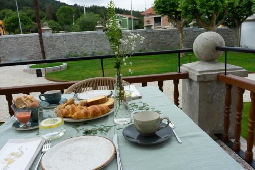 a table with a plate of bread and a cup of coffee at Hotel El Rosal de Cudillero in Cudillero