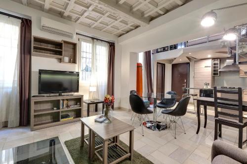 uma sala de estar com uma televisão, uma mesa e cadeiras em Servi 7C em Florença