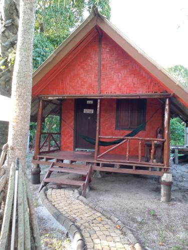 a small red cabin with a picnic table in front of it at Andaman Bay House in Ko Lanta
