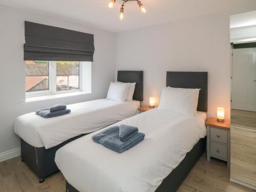 two beds in a small room with two lamps at 1 Staveley Cottages in Weaverthorpe