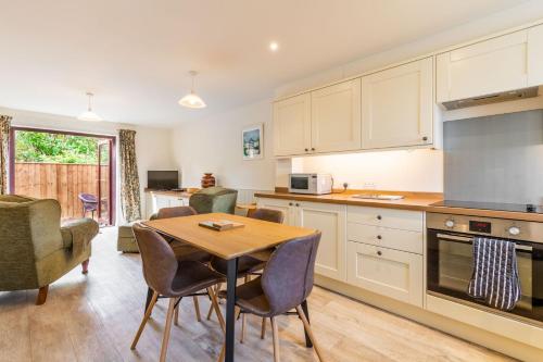 a kitchen and dining room with a table and chairs at Tystie Cottage in Salthouse