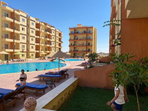 a swimming pool in a building with people walking around it at استوديو للعائلات داخل قرية Retal View north coast in El Alamein