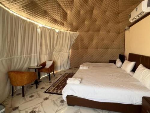 a bedroom with a bed and a table in a room at Wadi Rum Marcanã camp in Aqaba