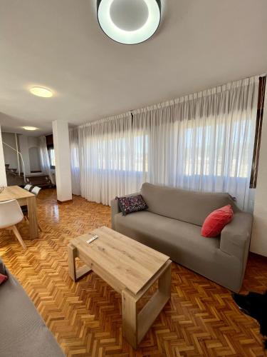 a living room with a couch and a coffee table at Duplex De los Reyes Católicos con parking incluido in Burgos