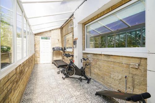 a gym with a brick wall and windows and exercise equipment at RentMySpaHome with Swimming Pool Hottub and Sauna in Sheffield