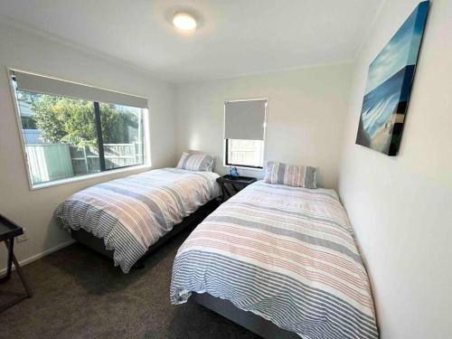 a bedroom with two beds and a window at Family Perfect, winter getaway, secure yard, parking, mountain bikes, arcade in Rotorua