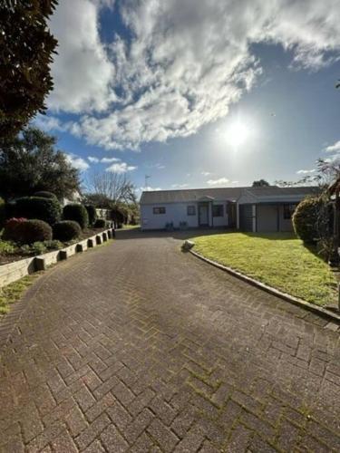 a brick driveway with a house in the background at Family Perfect, winter getaway, secure yard, parking, mountain bikes, arcade in Rotorua