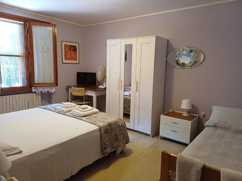 a bedroom with a bed and a desk and a mirror at Home Meditamondo in Fano