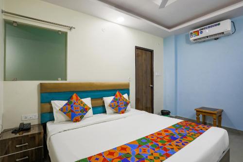 1 dormitorio con 1 cama grande con una manta colorida en FabHotel SM Palace, en Chinhat