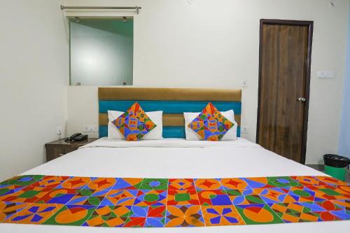 1 dormitorio con 1 cama con un edredón colorido en FabHotel SM Palace, en Chinhat