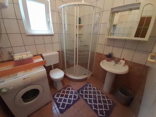 uma casa de banho com um chuveiro, um WC e um lavatório. em Apartmani "Rebecca" em Neum