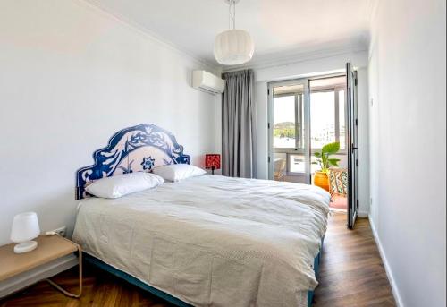 a bedroom with a large bed with a blue headboard at Loulé Old Town Apartment in Loulé