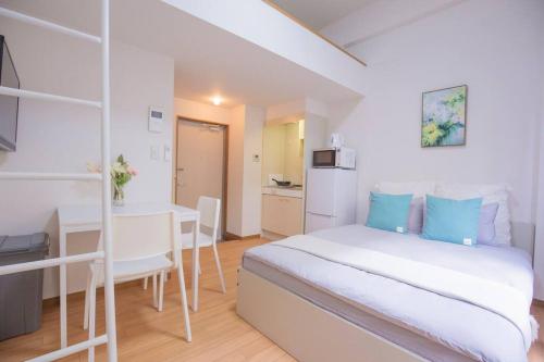 a bedroom with a bed and a desk and a kitchen at 閑静な住宅街_暖かく居心地の良いデザイン YoW-4 in Tokyo
