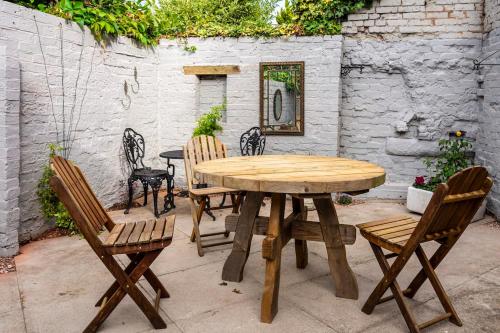 drewniany stół i krzesła na patio w obiekcie The Clockhouse Bewdley w mieście Bewdley