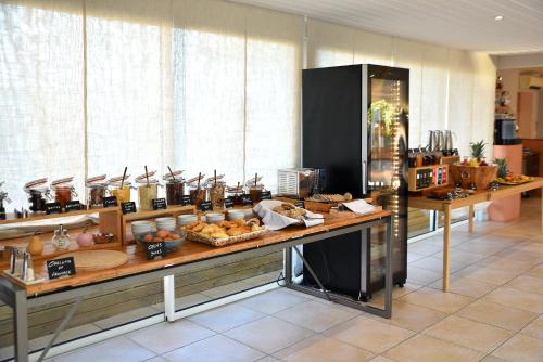 a buffet in a room with food on a table at Hôtel Alivi Di Santa Giulia in Porto-Vecchio