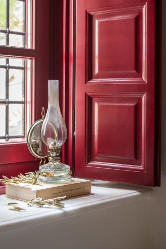 a glass vase sitting on a book next to a window at FOS Hydra residence in Hydra