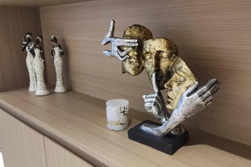a statue of a person holding a cross and a cup on a shelf at GTC Posh Hideaway in Westlands in Nairobi