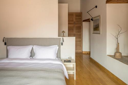 a bedroom with a bed with white pillows at FOS Hydra residence in Hydra