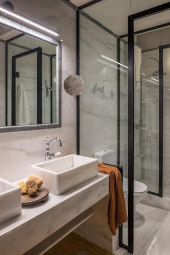 a bathroom with a sink and a glass shower at FOS Hydra residence in Hydra