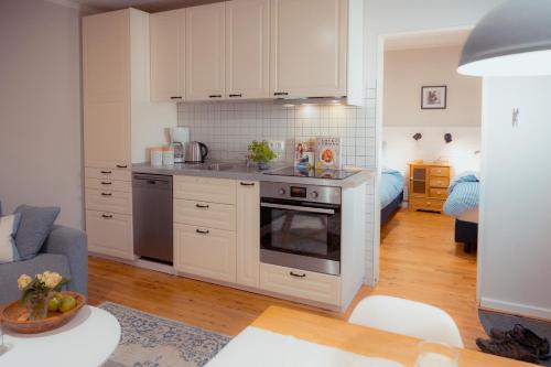 a kitchen with white cabinets and a living room at Seewind - a15221 in Westermarkelsdorf