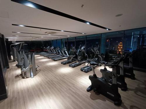 a gym with a row of treadms and cardio machines at CL 93B Balcony KLCC View Studio in Kuala Lumpur